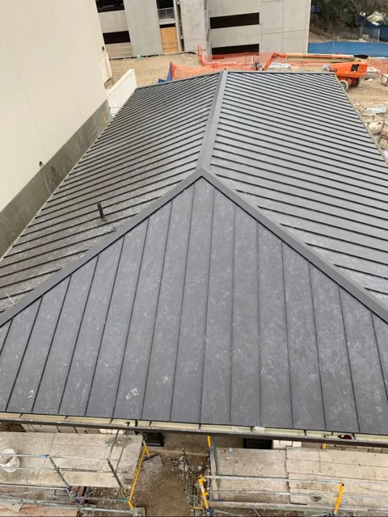 Commercial metal roof construction with crane equipment in Shelby